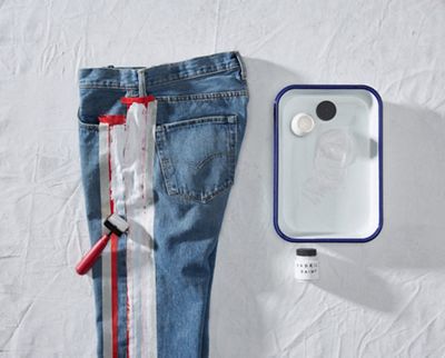 pair of jeans laying down with tape and paint