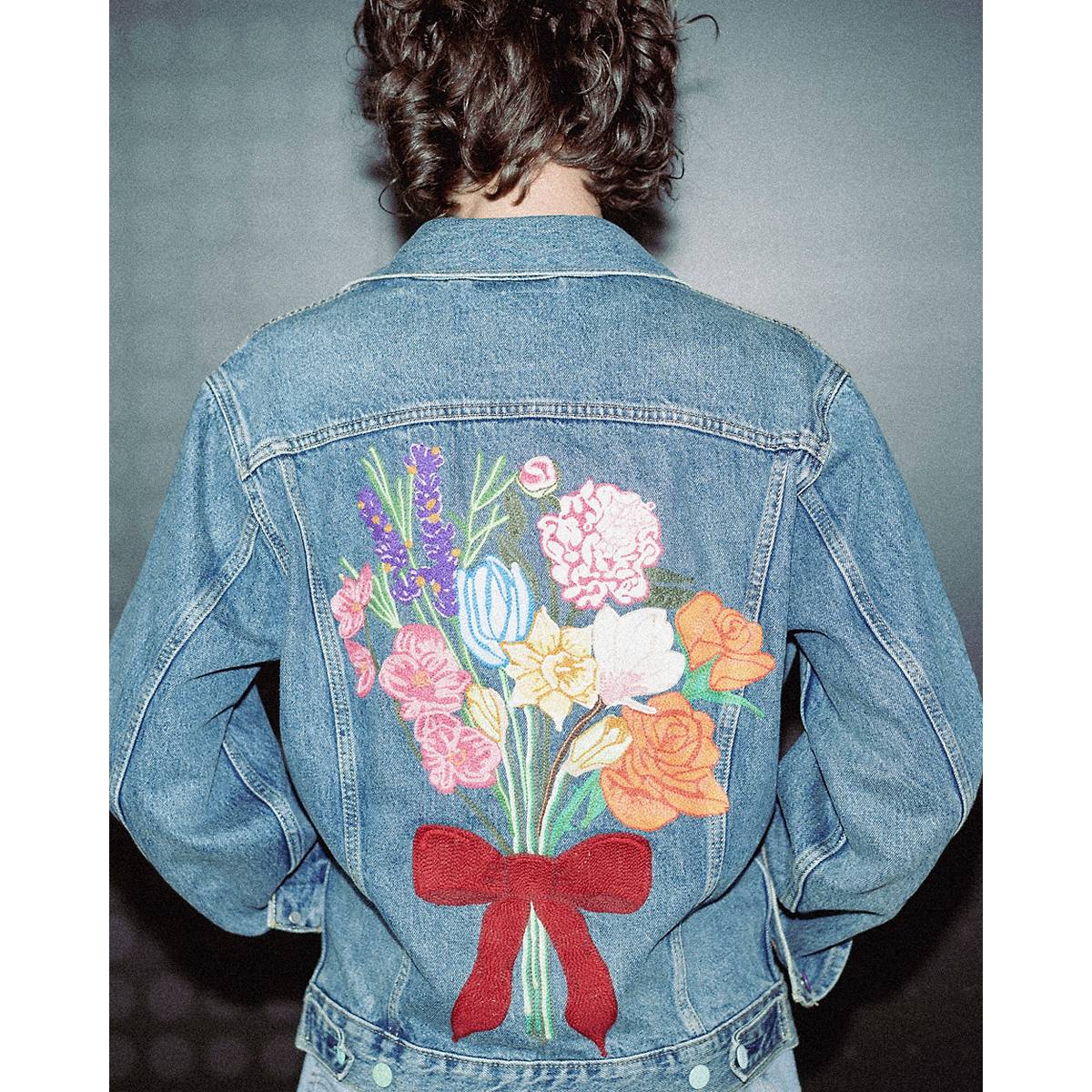 Detail shot of a white jacket with floral white, pink and orange embroidery
