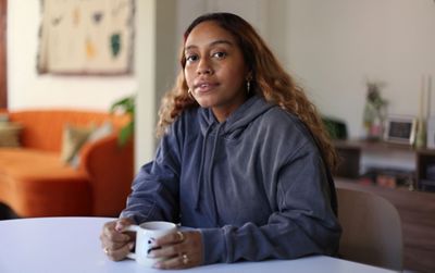 Portrait d’ABIR assise sur un perron, la tête reposant entre ses mains.