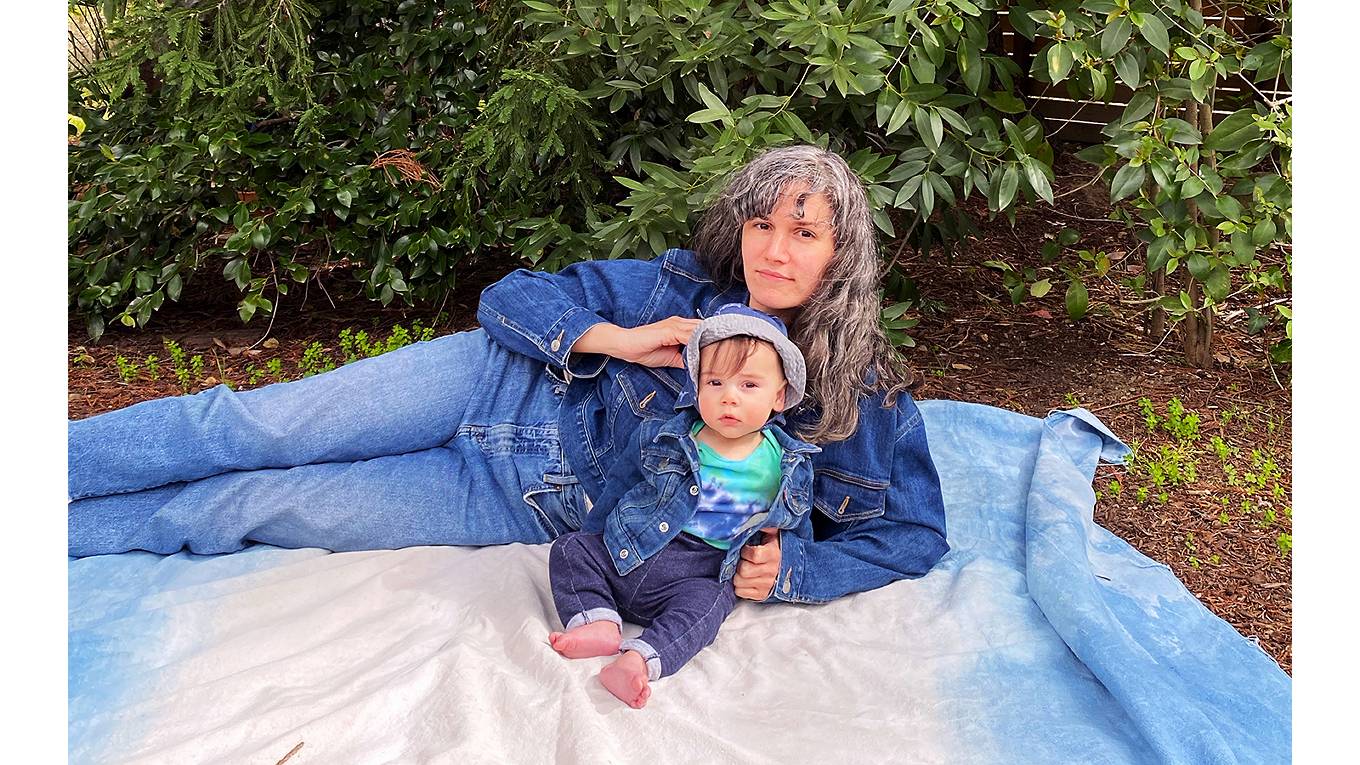 Silvia Llopis and her baby Nico sitting on a blacket in teh park wearing Levi's
