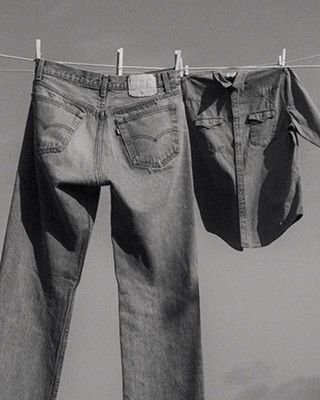 A black and white photo of jeans hanging on a clothing line