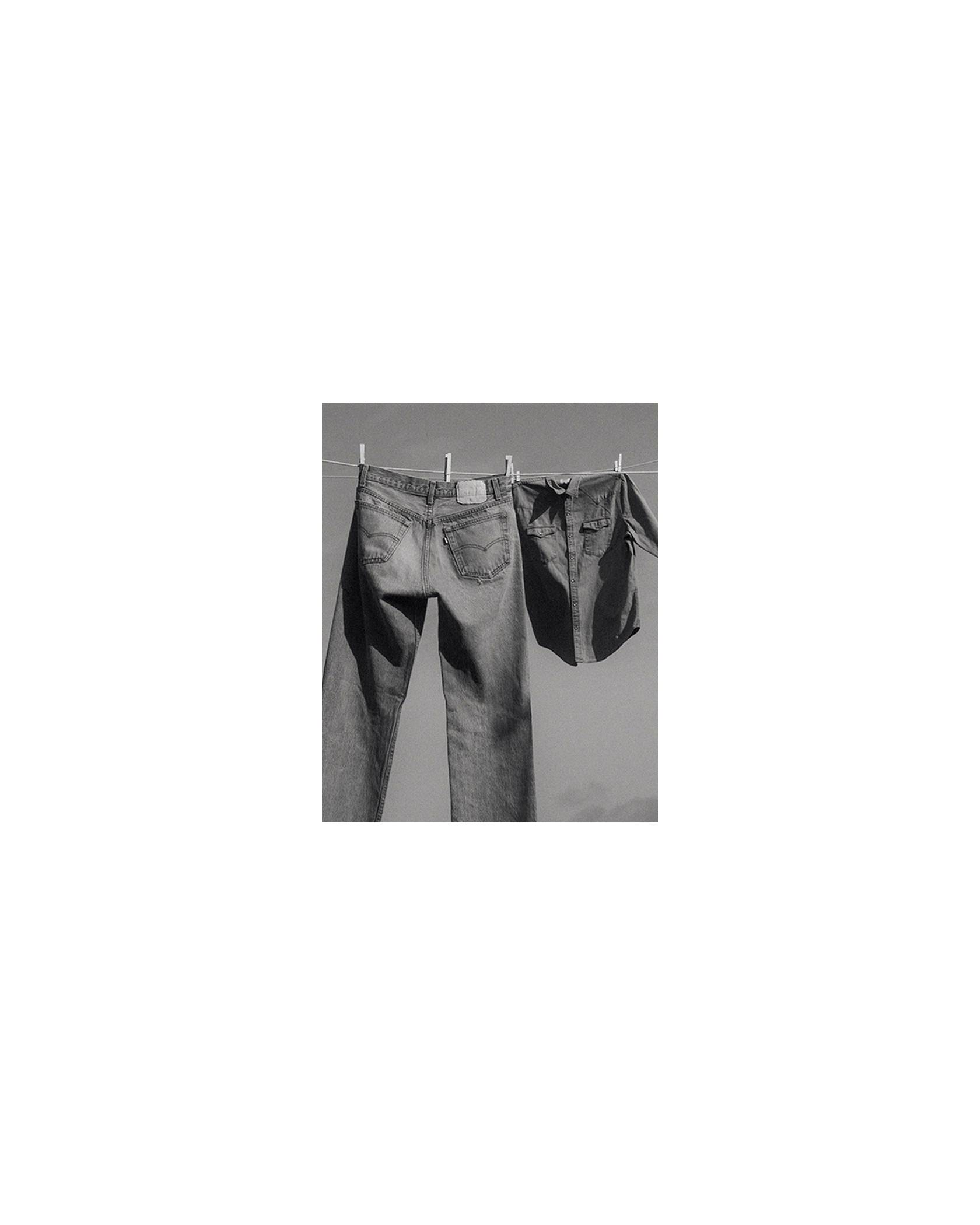 A black and white photo of jeans hanging on a clothing line