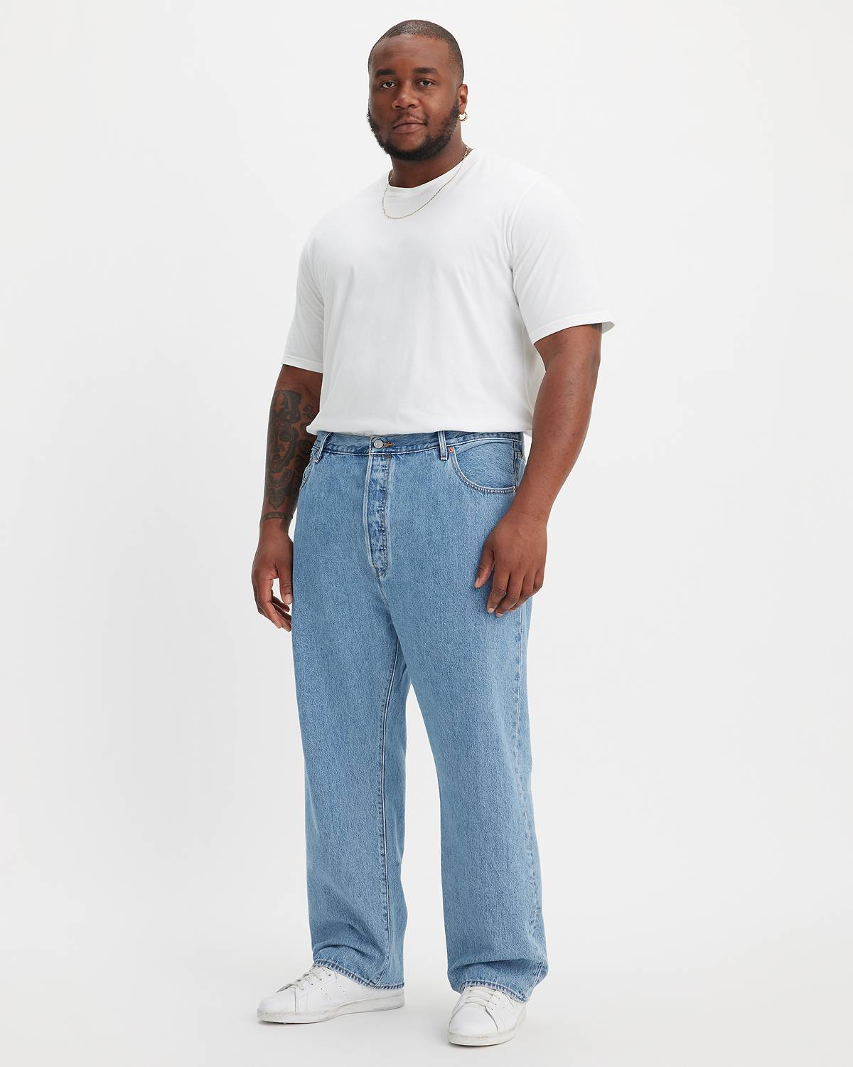 Big & tall male model wearing jean pants and a tee.