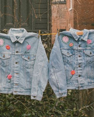 Image of seven customized jean jackets with embroidery by Bentgablenits hanging on a clothesline.