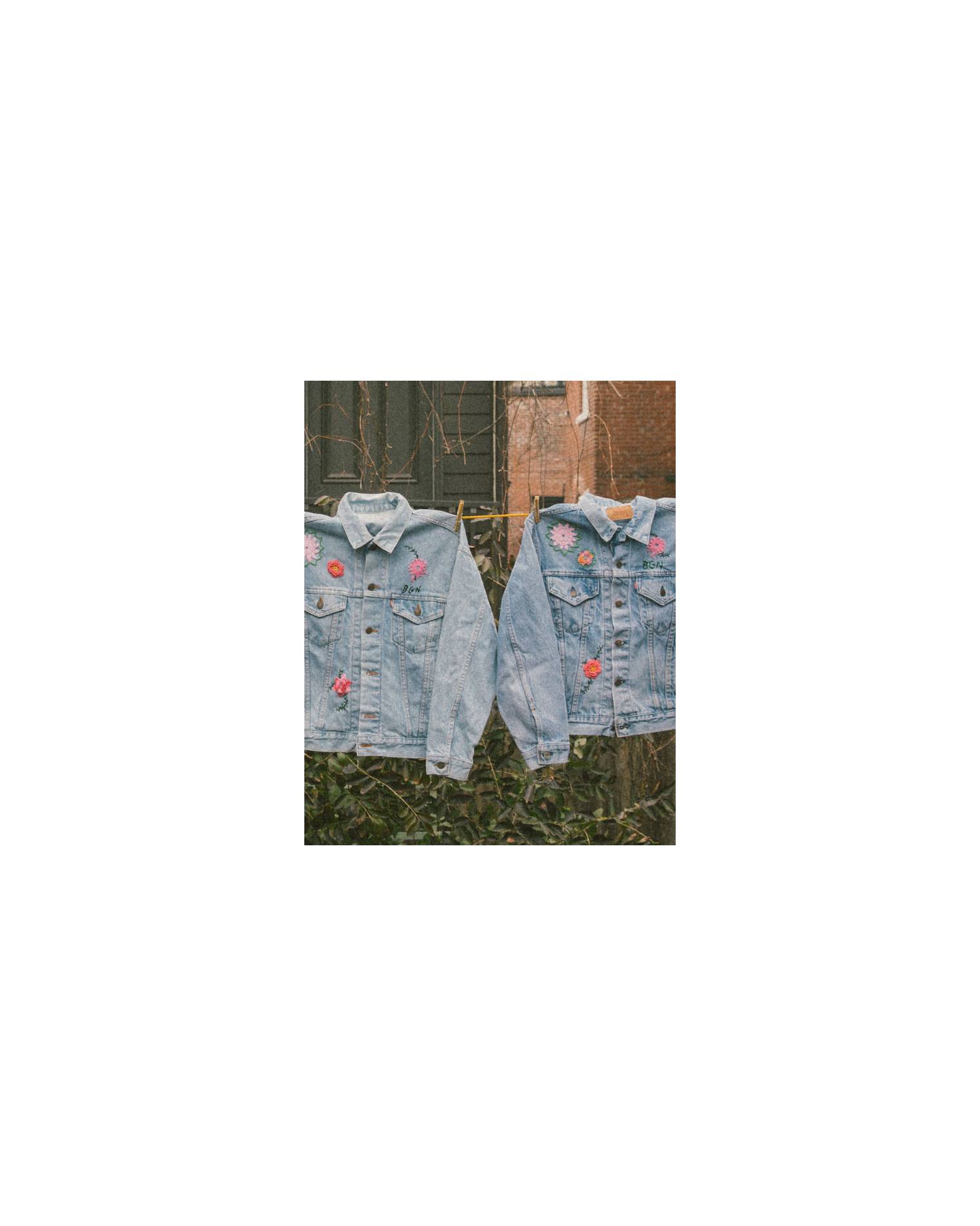 Image of seven customized jean jackets with embroidery by Bentgablenits hanging on a clothesline.