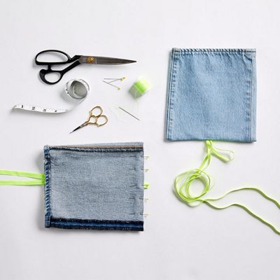 Image of pant leg with elastic cord centered and in a loop as well as the other pant leg with sewing pins to hold the raw edge fabric in place.