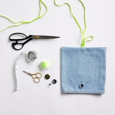 Image of button sewn on top of the pant leg with the green elastic band looped on it.