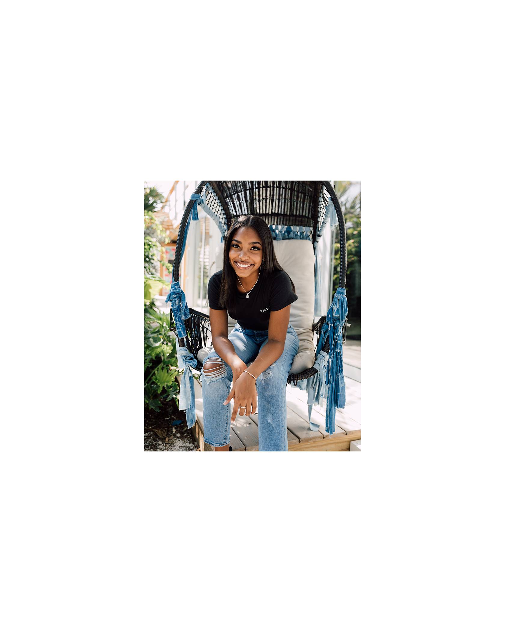 TikToker Gabby Morrison sits on a denim floating chair while wearing a black Levi's® tee shirt and Levi's® Future Finish light wash Wedgie jeans.