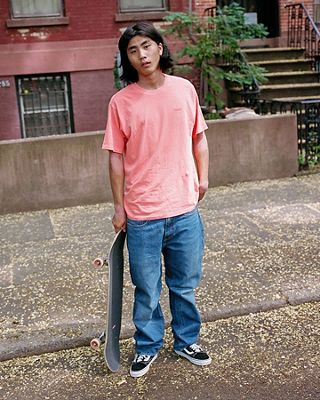 A man standing with a skateboard