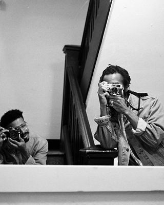 Black and white selfie of Joonbug and friend Kameron holding their cameras.