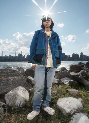 A model wearing Levi's sustainable loose straight jeans standing in front of a city and lake