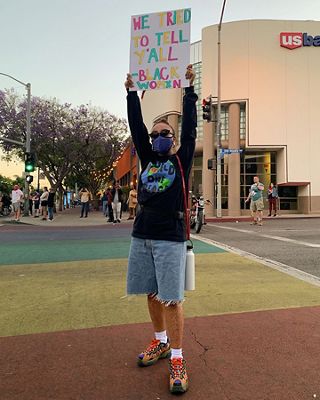 Photo of Evelynn Escobar-Thomas holding a sign at a protest.