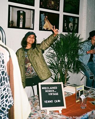 Photo of Tahia Islam making a peace sign at a Reclaimed Womxn Vintage sale.