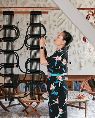 Image of Windy Chien working on a fiber sculpture in her studio.