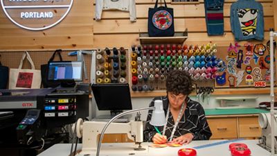 Emily Carrig sitting at her sewing machine