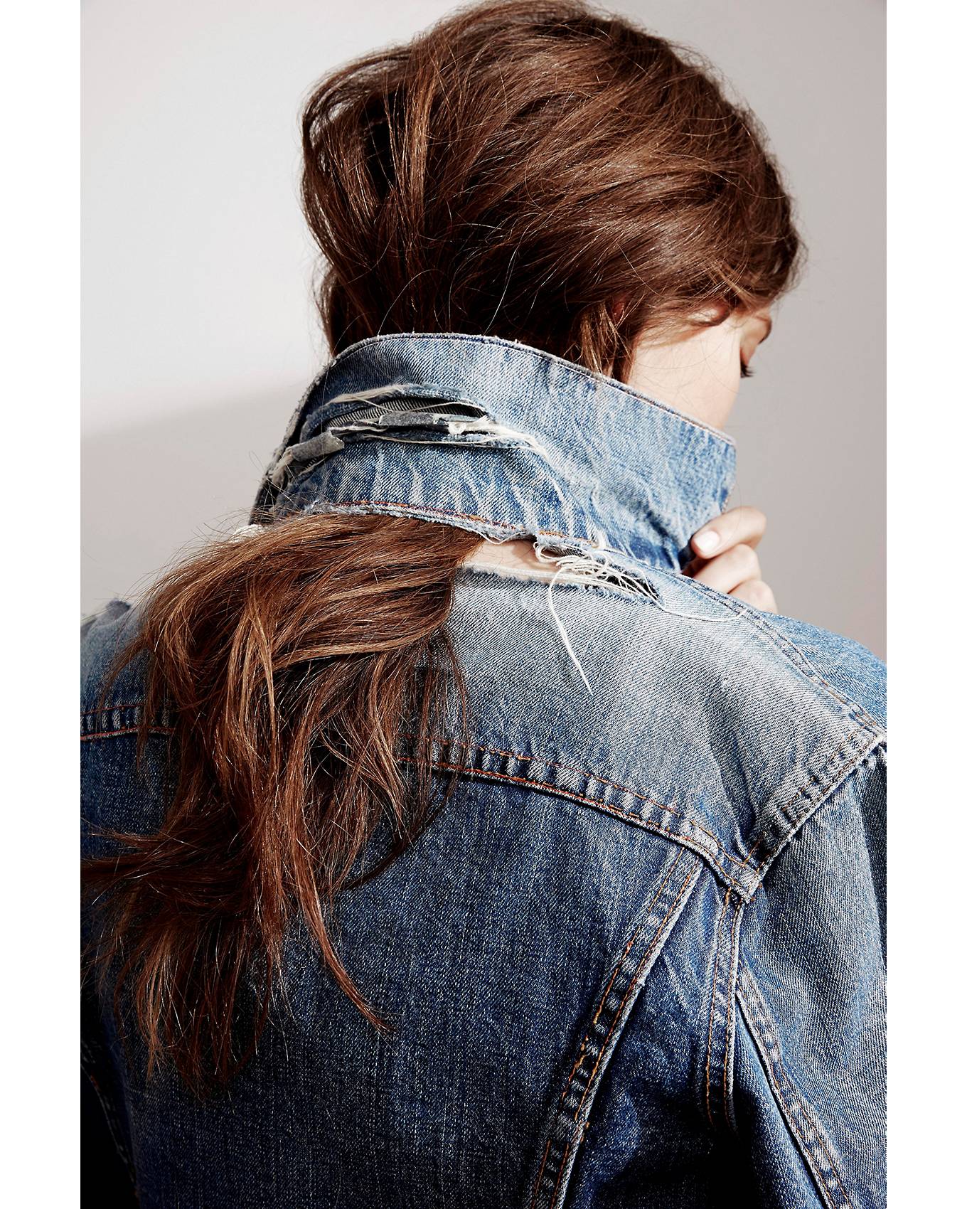 denim jacket. women's hair caught through the back