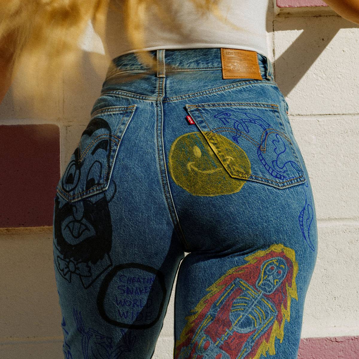 Image of model's backside wearing jeans with hand made doodles/illustrations