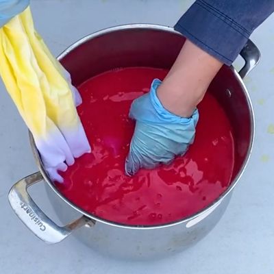 dye garment in pot with red paint