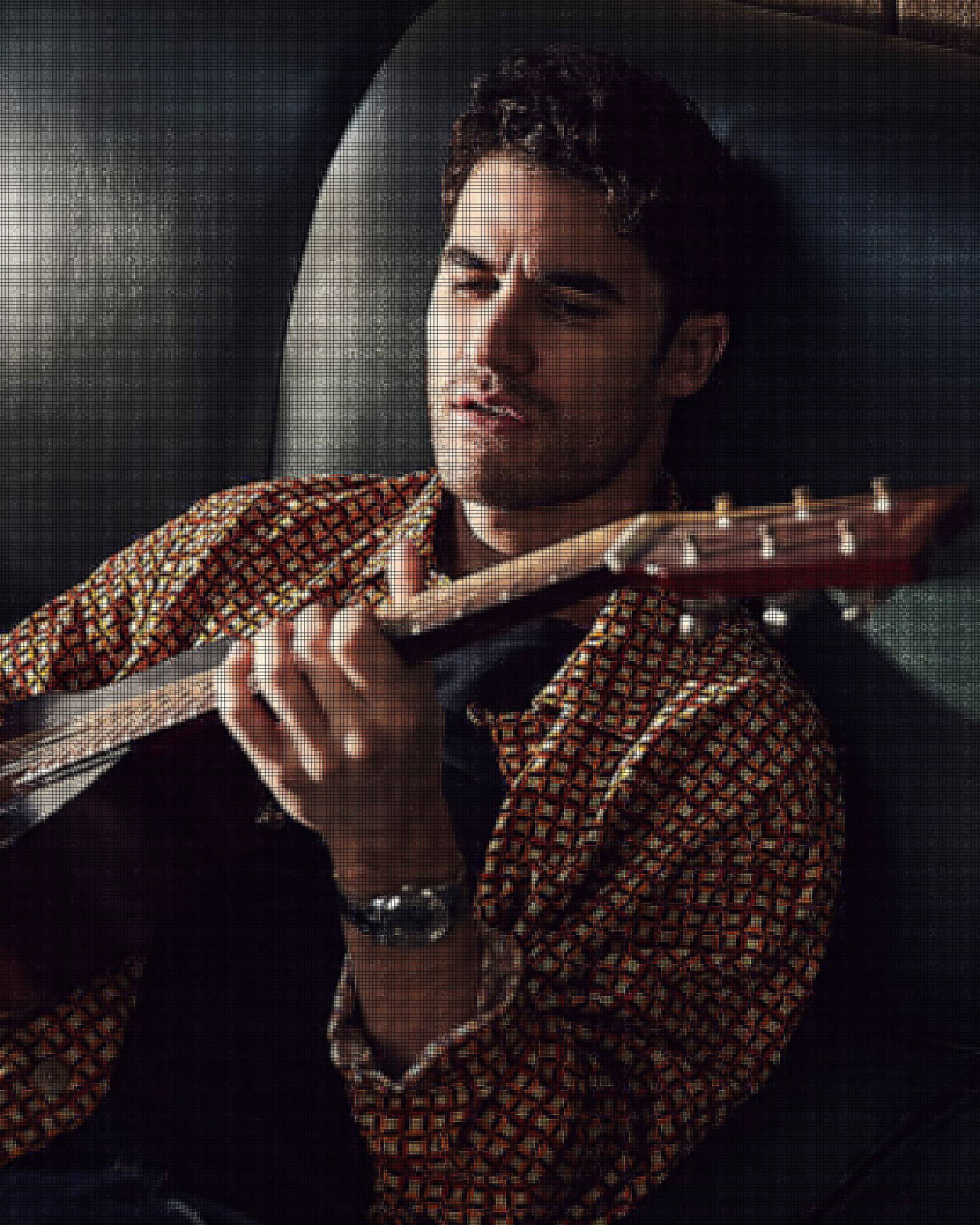 DARREN CRISS sitting on the couch playing guitar.