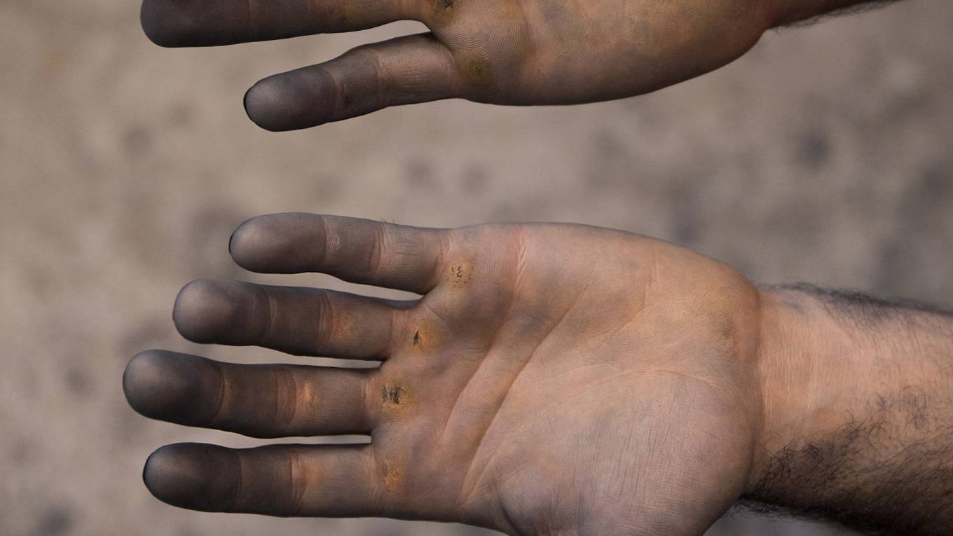 Image of pair of hands covered in dirt.