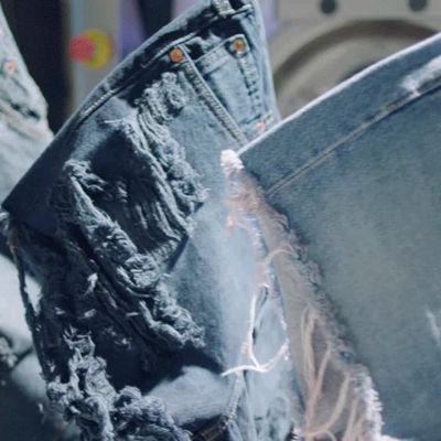 Video of the patches, sewing machines, and thread used to custom make a pair of Levi's® denim shorts with the video ending with someone holding up a pair of customized, distressed, light wash shorts.