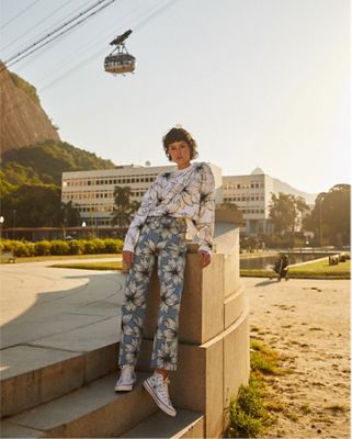 Woman wearing Levi x FARM Rio white sweatshirt with blue flowers and Levi x Farm Rio jeans with white flowers on them