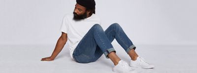 man posing on ground in jeans