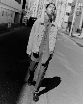 man standing on street in denim jacket