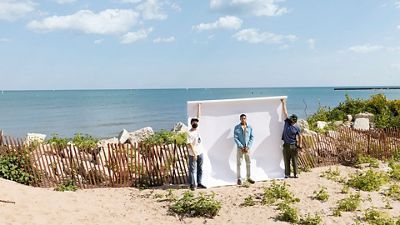 Image of photoshoot models wearing clothes on beach