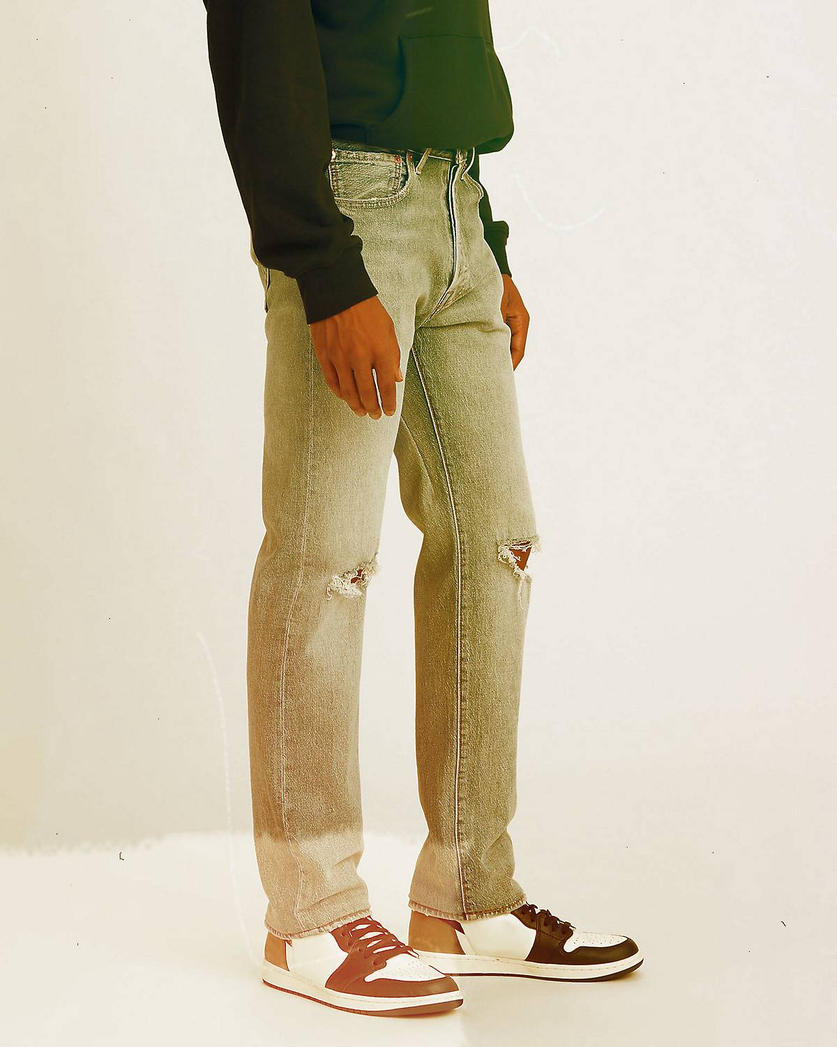 Man wearing jeans behind white wall