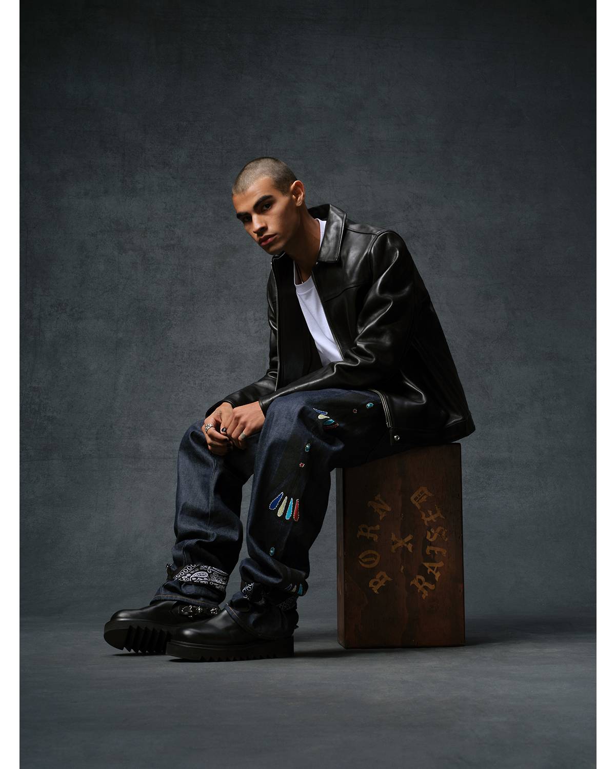 Image of model wearing a black leather jacket, white tee shirt and dark wash denim jeans from the Levi's® & Born x Raised capsule collection.