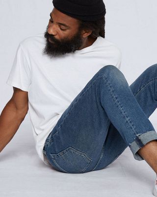man posing on ground in jeans