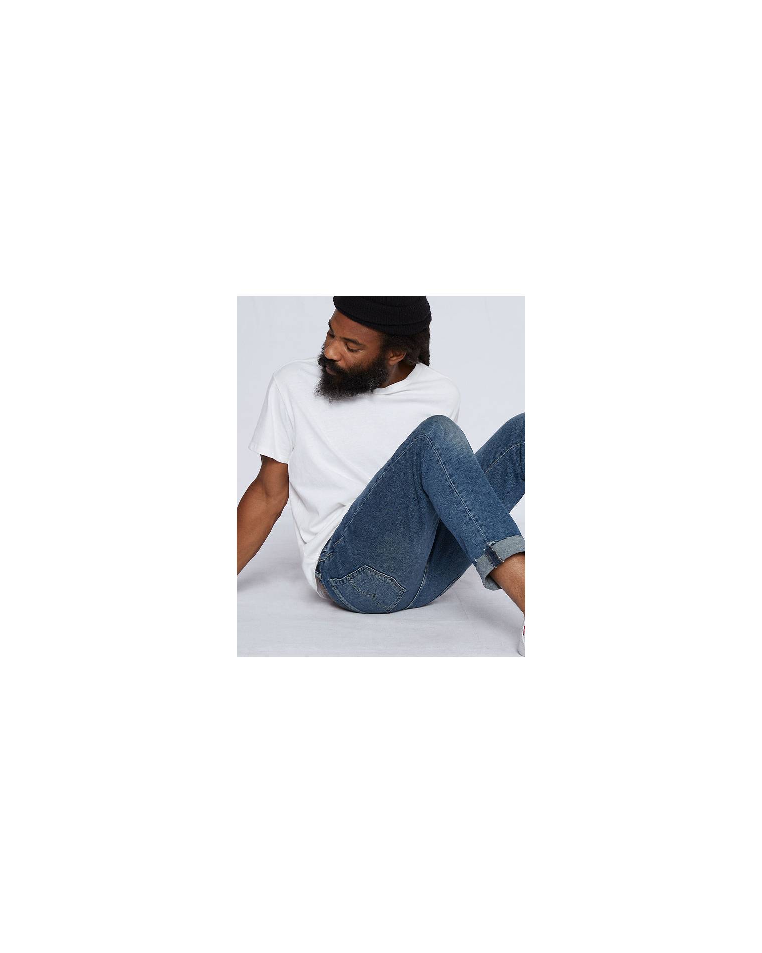 man posing on ground in jeans