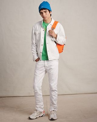 man in white jeans outfit with hat