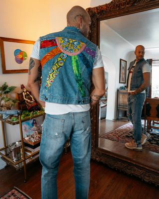 Wujek standing looking in a mirror wearing the custom trucker jacket