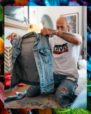 Johnny Wujek holding up a denim trucker jacket