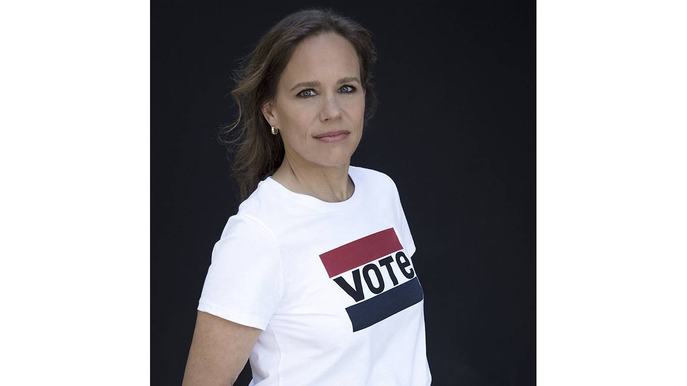 Image of woman wearing a white levi's shirt with a black background.