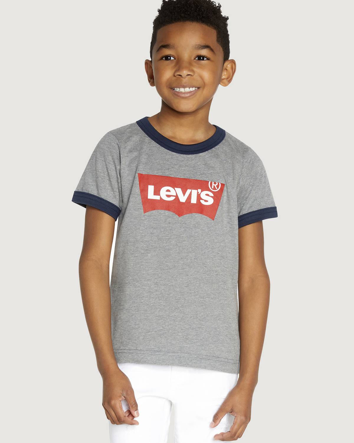 Little boy model wearing shorts and a tee.