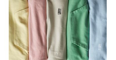 Five colorful sweatshirts folded next to eachother.