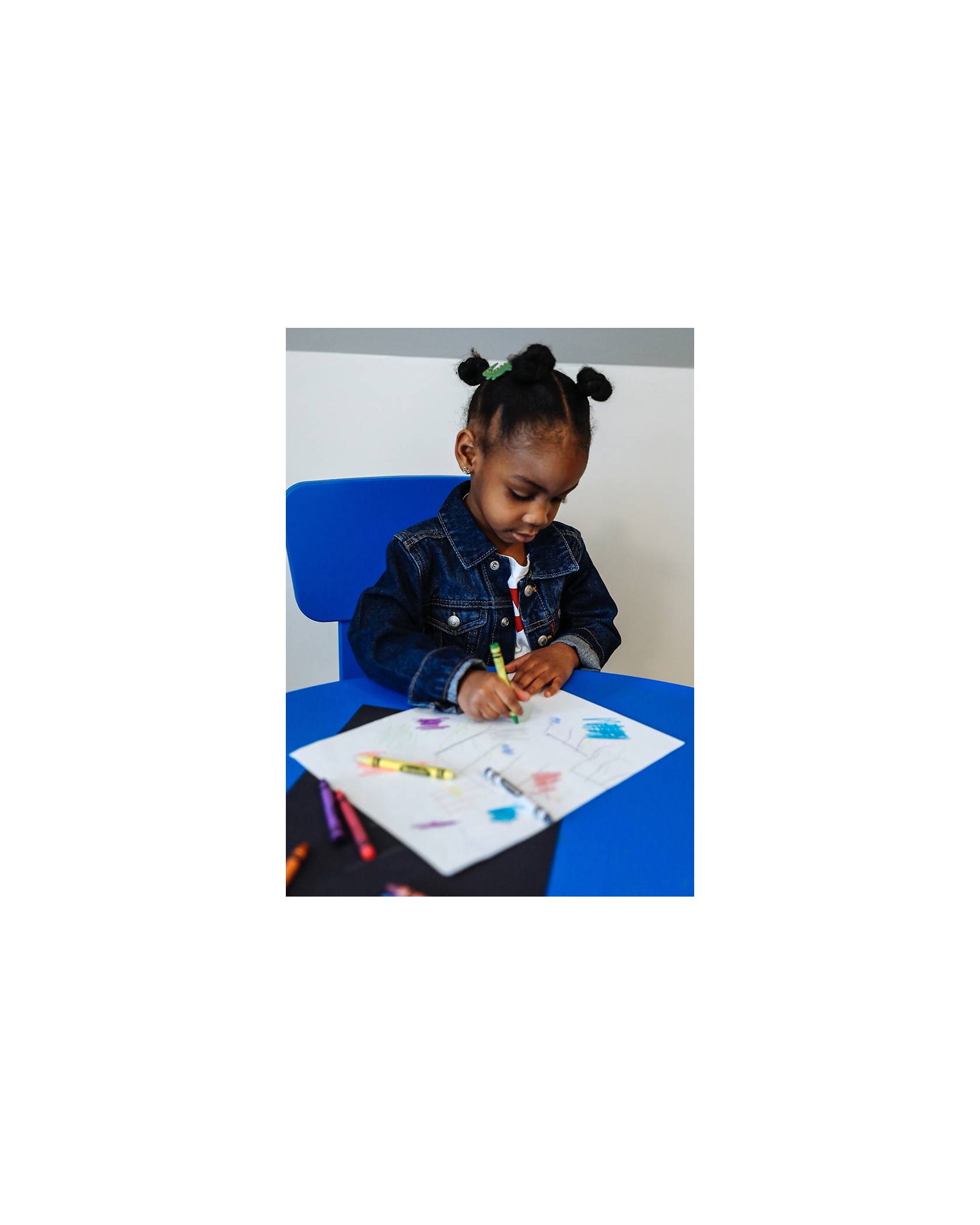 Photo of Emory Walker drawing with crayons. She is wearing a kids Levi's Trucker Jacket.