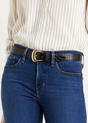 Close up image of a model wearing Levi's® medium wash jeans, a white blouse and a black belt with a gold buckle.