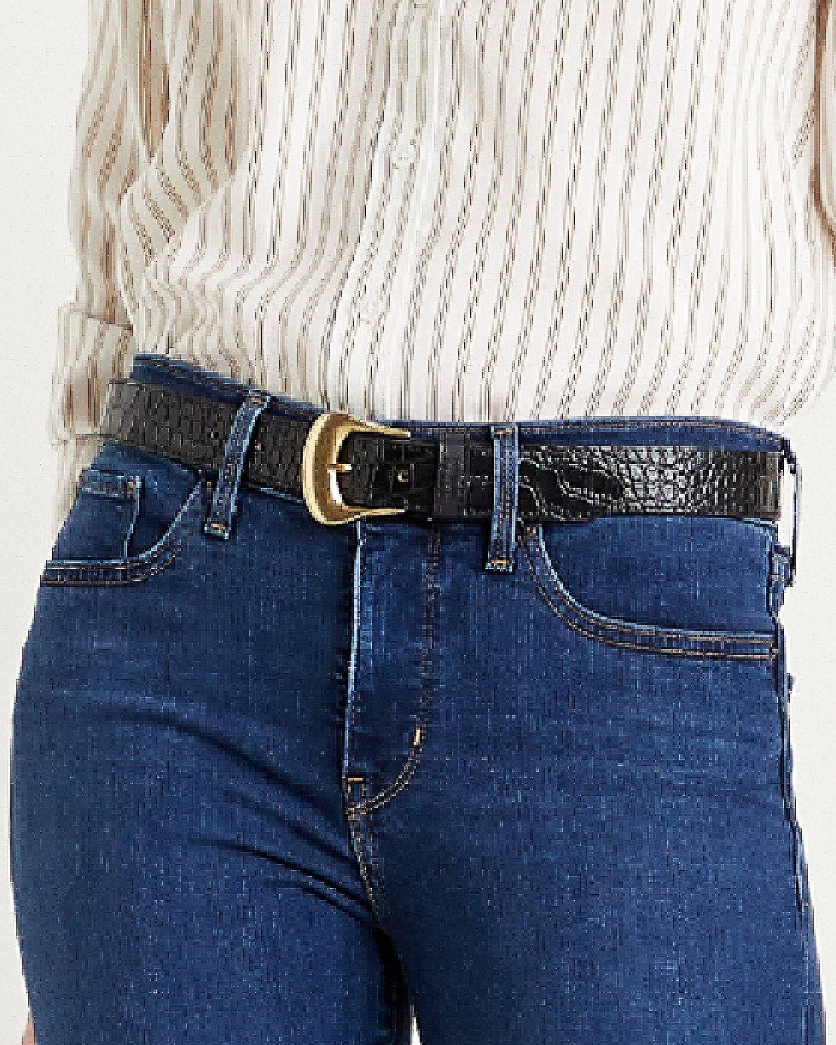Close up image of a model wearing Levi's® medium wash jeans, a white blouse and a black belt with a gold buckle.