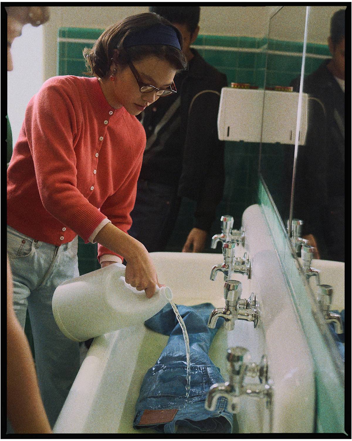 People bleaching their jeans in a bathroom.