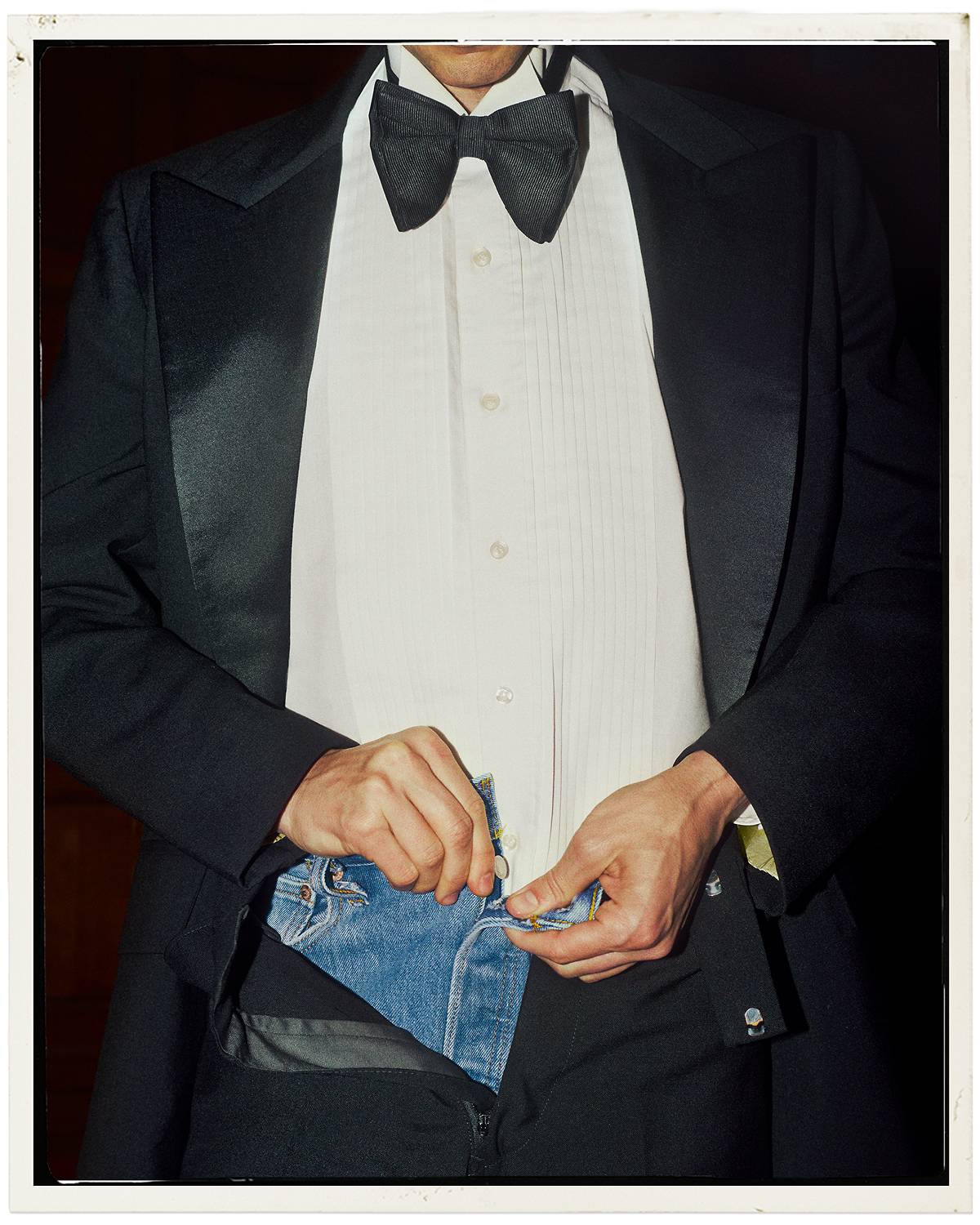 Person wearing blue jeans under their tuxedo.