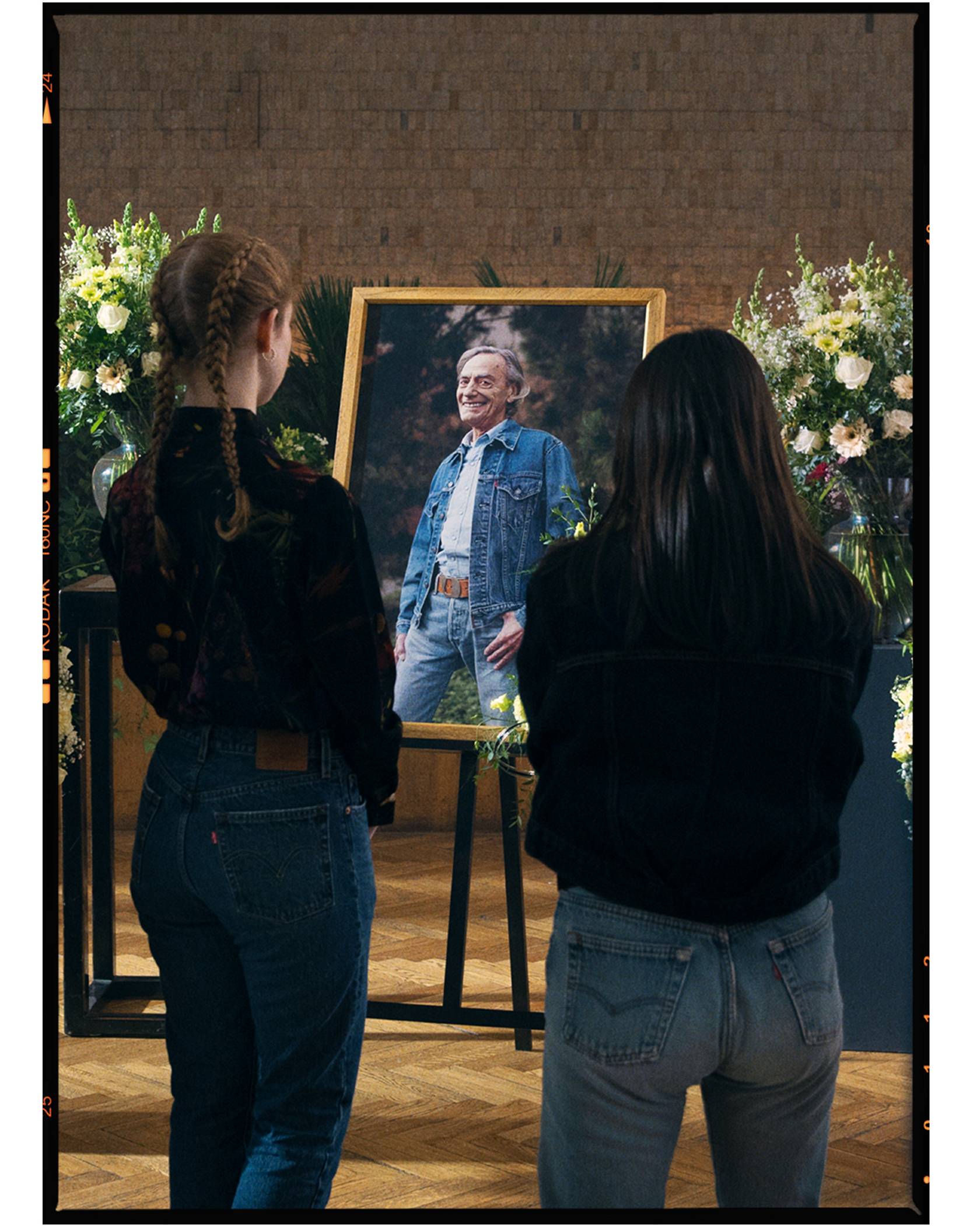 People wearing Levi's jeans at a funeral looking at a picture of the person who passed who is wearing Levi's jeans and a Trucker Jacket.