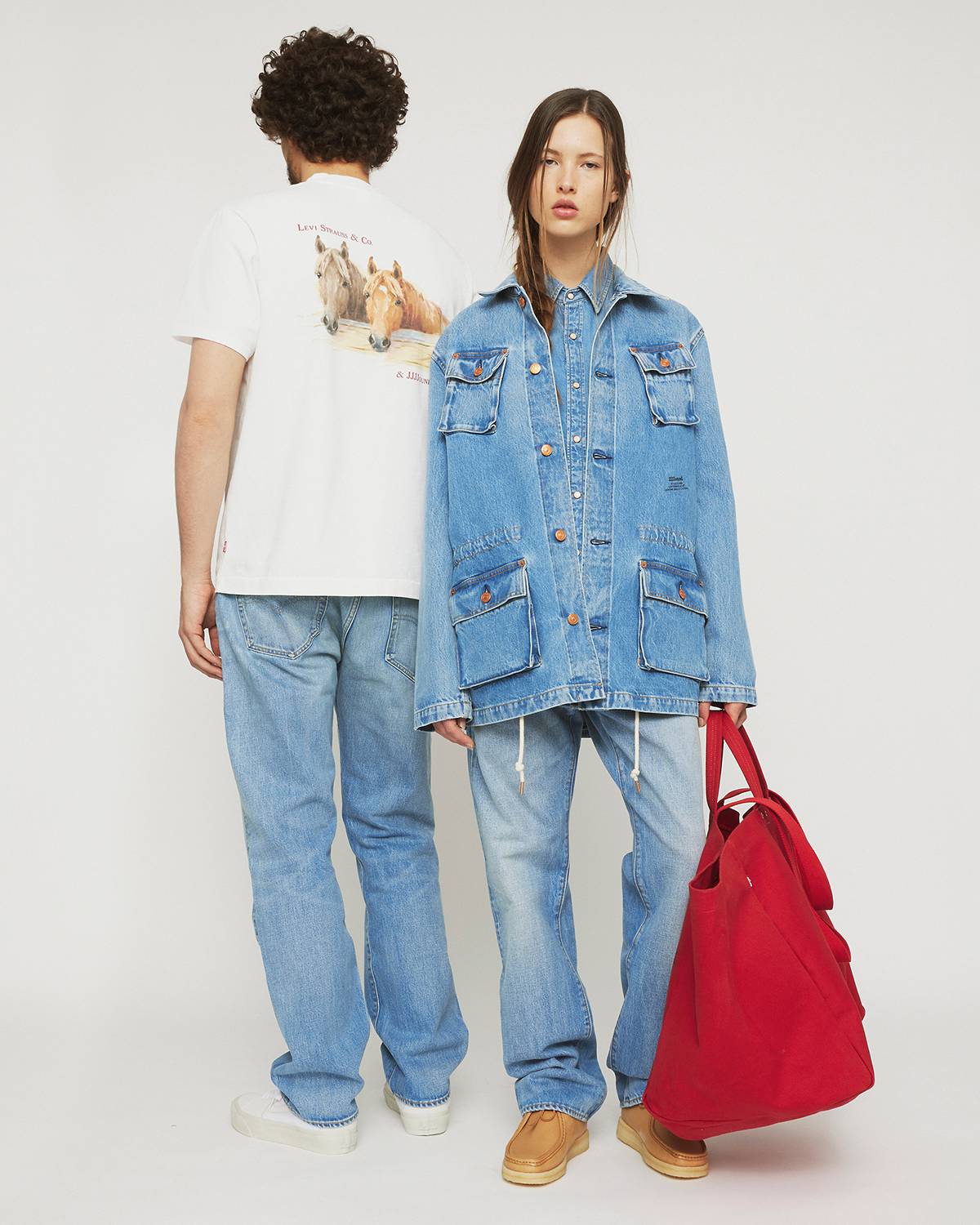 Man on the left wearing a white tee and jeans and woman on the right wearing a trucker jacket and jeans from the Levi's® x JJJJound collaboration.