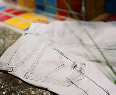 Lay-down image of a pair of white Levi's jeans.