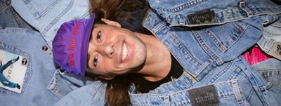 Photo of Sam Trotman lying on pile of denim.