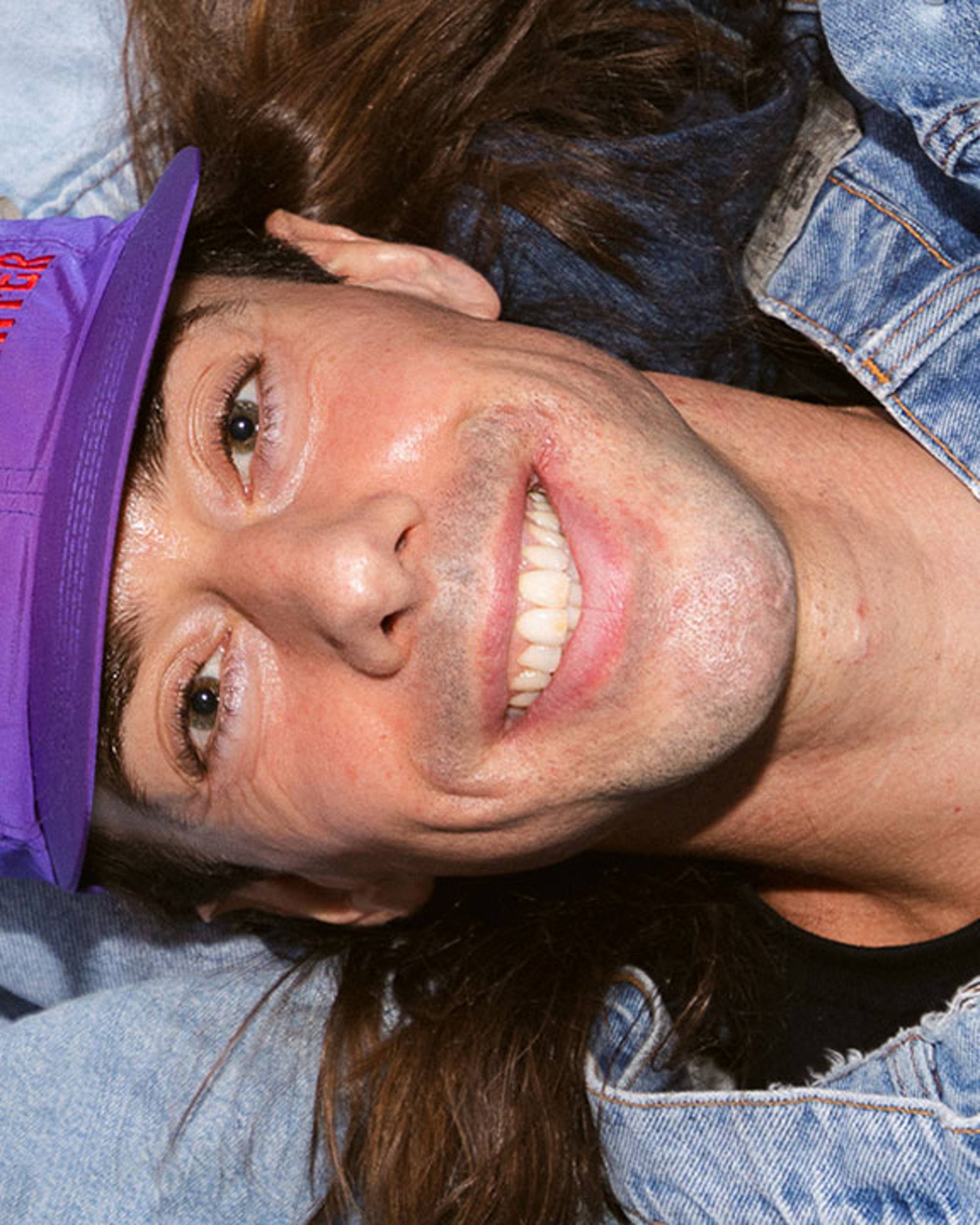 Photo of Sam Trotman lying on pile of denim.