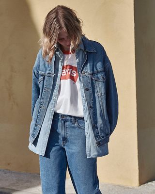 Woman outdoors in layered graphic ringer tee, denim shirt and Trucker with jeans 2022_fall_outfits_for_women